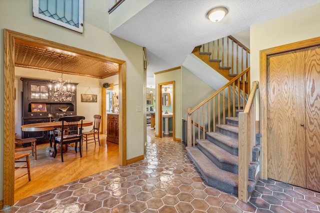 entrance foyer with a textured ceiling, a chandelier, and tile patterned flooring