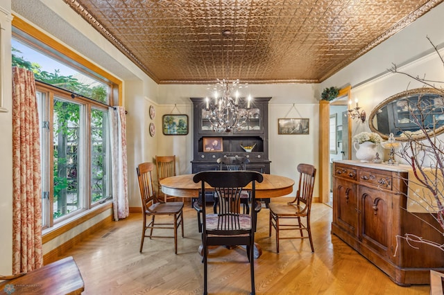 dining space with crown molding, a chandelier, and light hardwood / wood-style floors