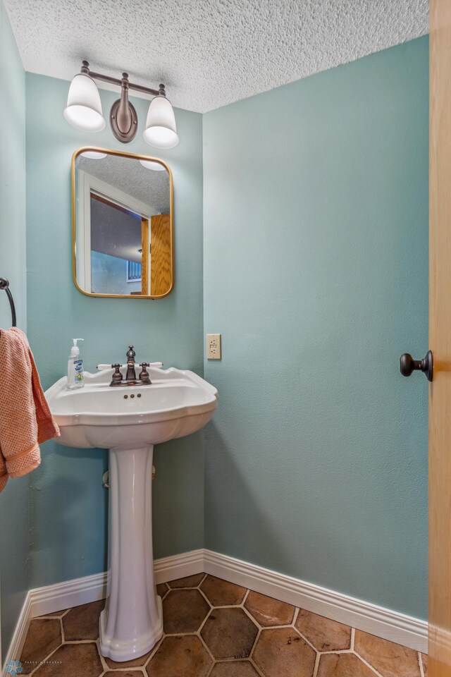 bathroom featuring tile patterned floors and a textured ceiling