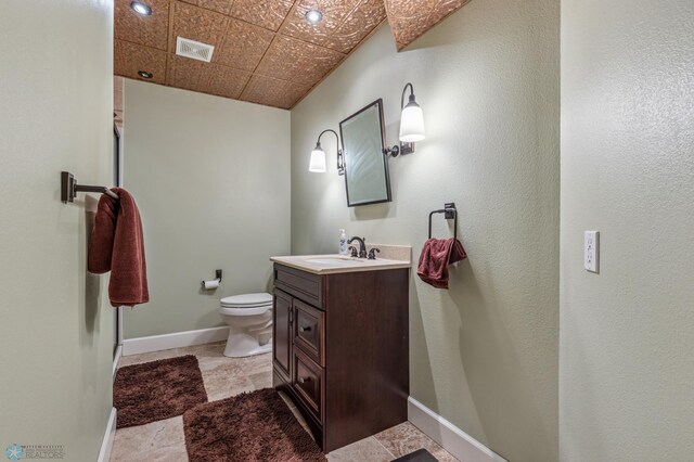 bathroom with toilet, tile patterned floors, and vanity