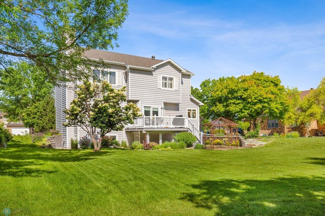 back of property with a wooden deck and a lawn