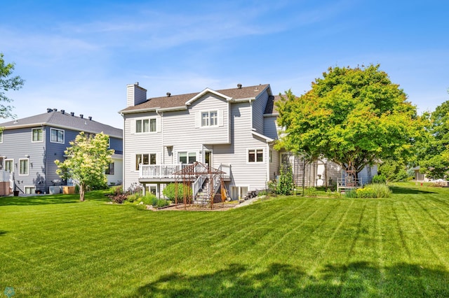 rear view of house with a yard and a deck