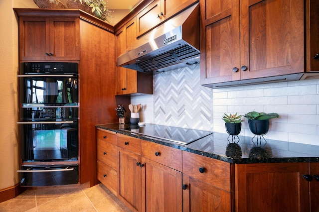 kitchen featuring ventilation hood, dark stone countertops, decorative backsplash, light tile patterned floors, and black appliances