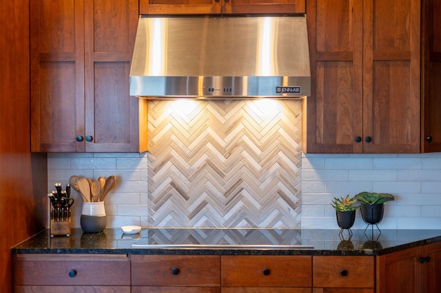 kitchen featuring tasteful backsplash, black electric cooktop, dark stone counters, and wall chimney exhaust hood