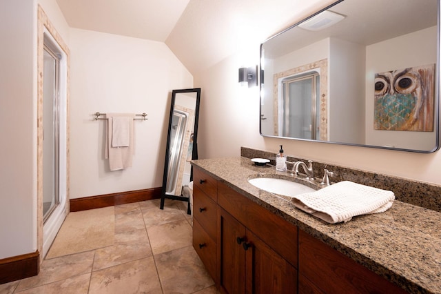 bathroom featuring lofted ceiling, vanity, and a shower with door