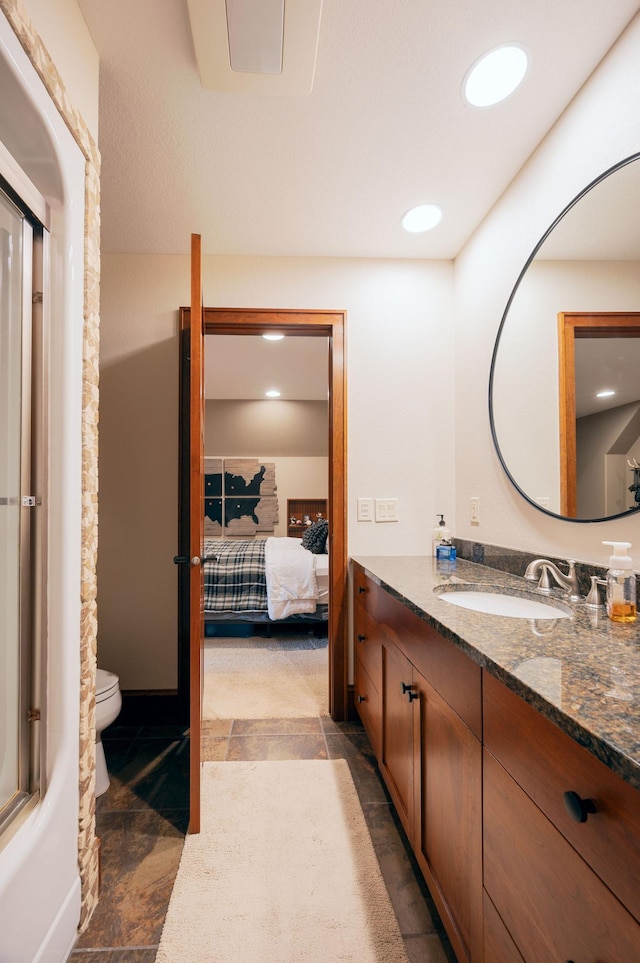 full bathroom featuring vanity, shower / bath combination with glass door, and toilet