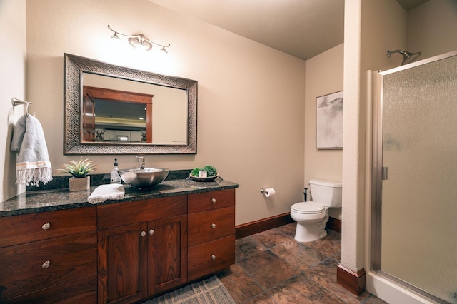 bathroom with vanity, a shower with door, and toilet