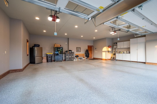 garage featuring stainless steel refrigerator and a garage door opener