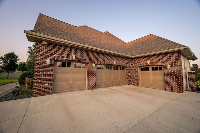 property exterior at dusk featuring a garage