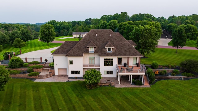 back of property featuring a wooden deck, a balcony, and a garage