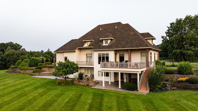 back of property with a yard, a deck, and a patio area