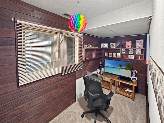 carpeted home office with wood walls