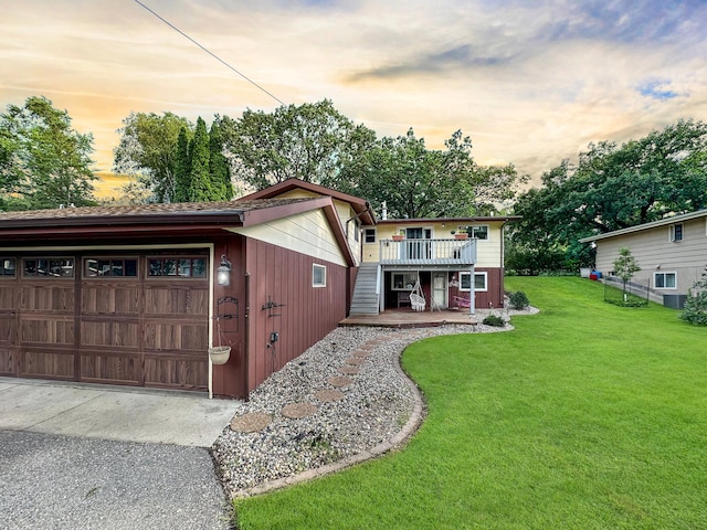 view of front facade with a wooden deck, a yard, and a garage