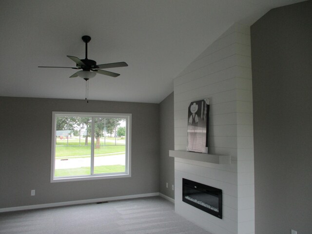 unfurnished living room featuring a fireplace, lofted ceiling, ceiling fan, and carpet floors