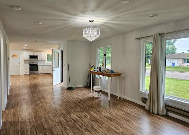 unfurnished dining area featuring recessed lighting, baseboards, a notable chandelier, and dark wood-style flooring