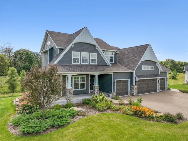 craftsman-style house featuring covered porch, a front lawn, and a garage