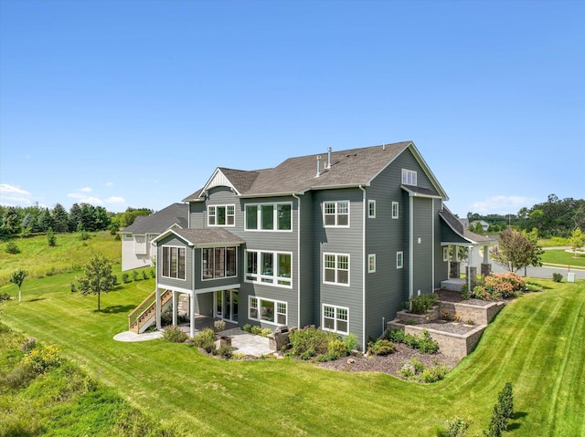 rear view of house with a yard, a sunroom, and a patio area