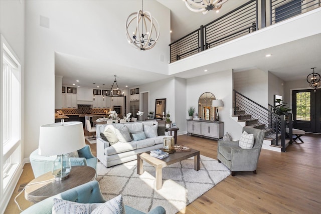 living room with light hardwood / wood-style flooring and a towering ceiling