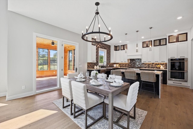 dining room with light hardwood / wood-style flooring and a notable chandelier