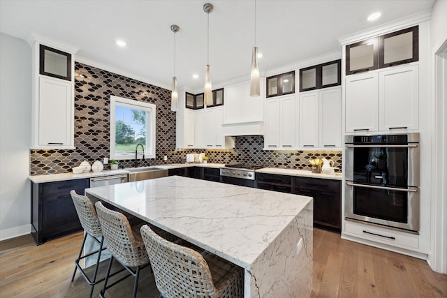 kitchen featuring stainless steel appliances, hanging light fixtures, backsplash, and a kitchen island