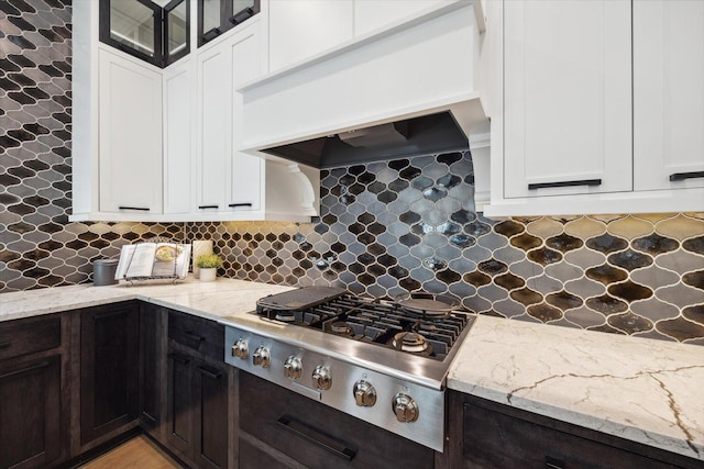 kitchen with dark brown cabinetry, decorative backsplash, custom range hood, and stainless steel gas stovetop