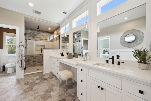 bathroom featuring toilet, an enclosed shower, and vanity