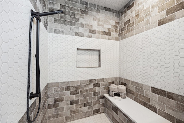 bathroom with tile walls and a tile shower