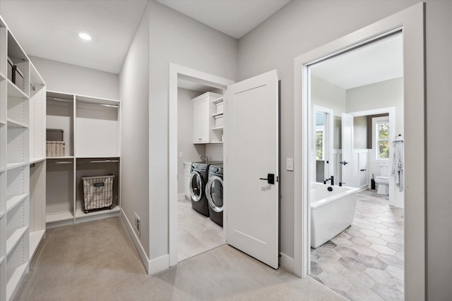 laundry area featuring cabinets, independent washer and dryer, and light colored carpet