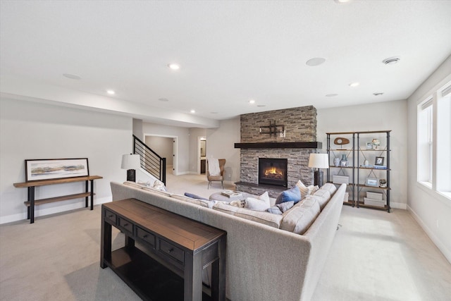 living room with a stone fireplace and light carpet