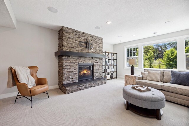 living room with light carpet, a textured ceiling, and a fireplace