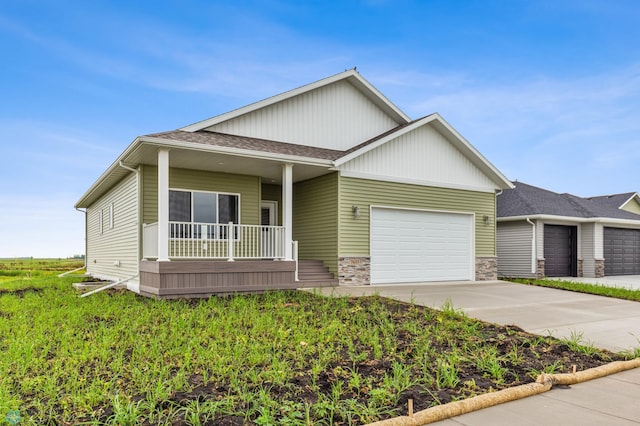view of front of home featuring a garage, covered porch, and driveway