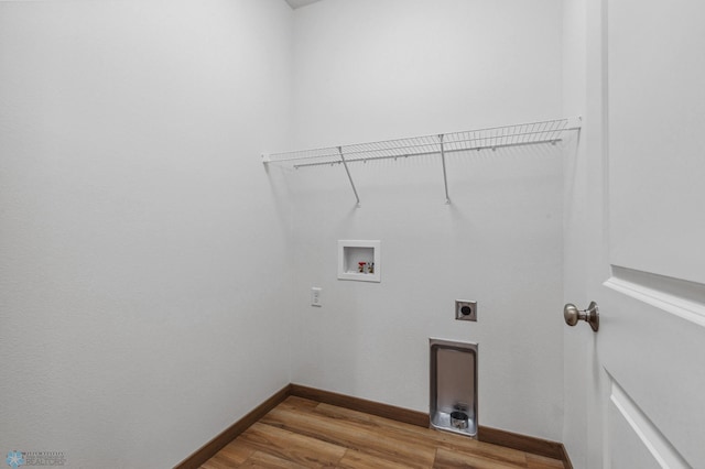 washroom with hookup for an electric dryer, laundry area, wood finished floors, baseboards, and hookup for a washing machine