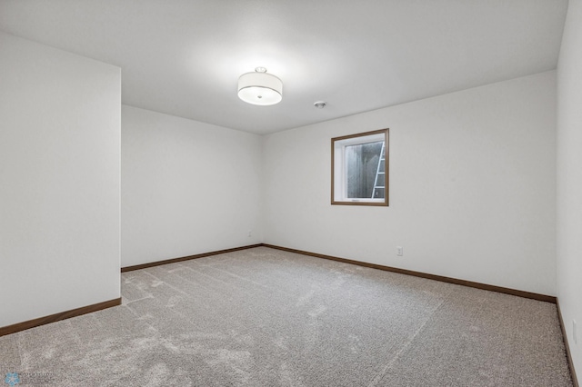 carpeted spare room with baseboards