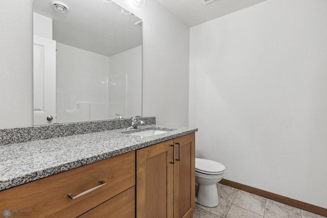 bathroom with toilet, baseboards, marble finish floor, and vanity