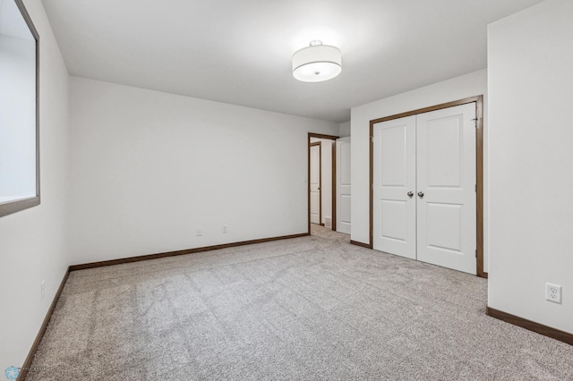 unfurnished bedroom with carpet floors, baseboards, and a closet