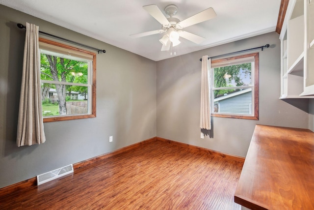 spare room featuring ceiling fan, plenty of natural light, and wood-type flooring