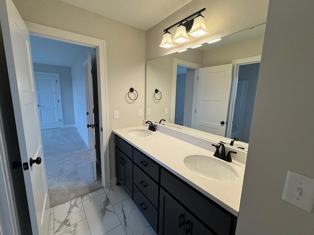 full bathroom featuring marble look tile flooring, double vanity, and baseboards