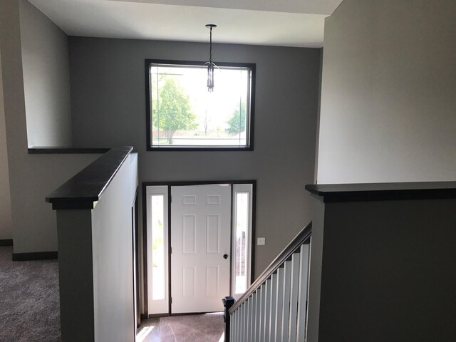 entrance foyer with dark colored carpet