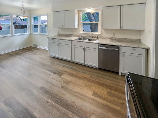 kitchen featuring white cabinetry, stainless steel dishwasher, plenty of natural light, and light hardwood / wood-style floors