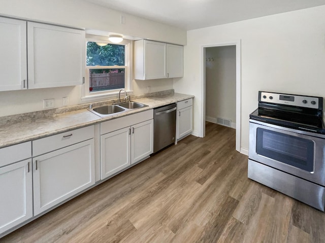 kitchen featuring light hardwood / wood-style flooring, appliances with stainless steel finishes, and white cabinetry