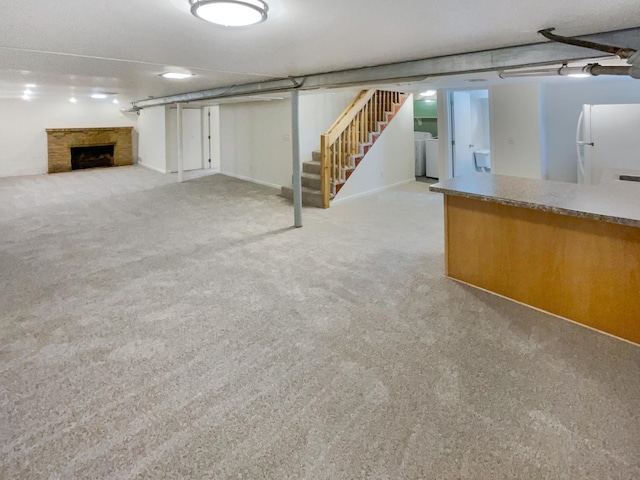 basement with white refrigerator, washer / clothes dryer, and light carpet