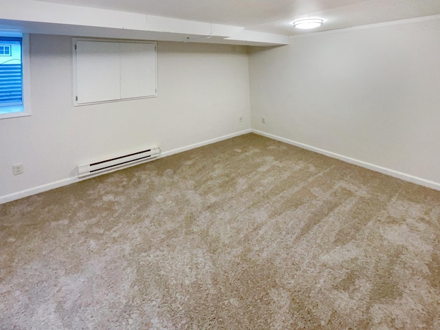 spare room with carpet flooring and a baseboard radiator