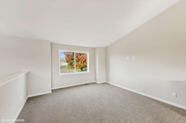 carpeted spare room with lofted ceiling