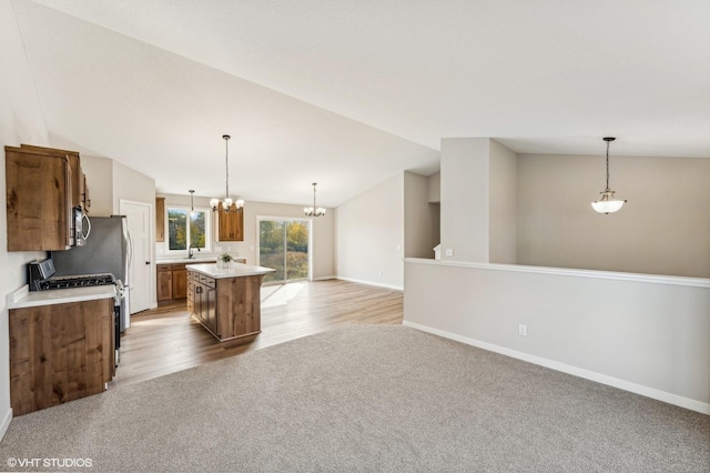 kitchen with gas range gas stove, pendant lighting, vaulted ceiling, and a center island