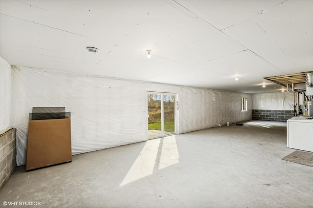 basement with electric water heater and washer / dryer