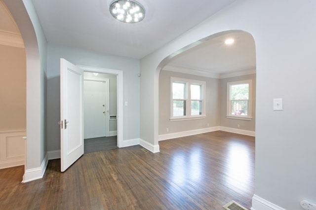 empty room with dark wood-type flooring and crown molding