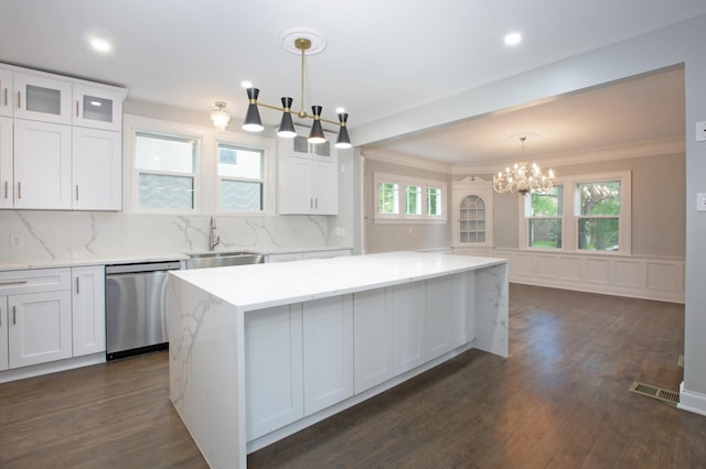 kitchen with white cabinets, stainless steel dishwasher, pendant lighting, and a kitchen island