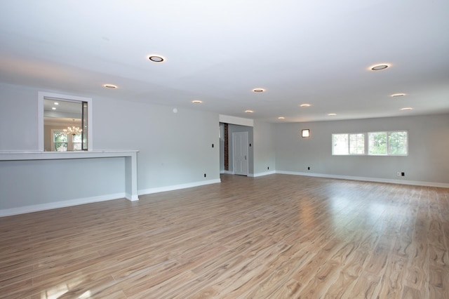 spare room featuring light hardwood / wood-style floors and a notable chandelier