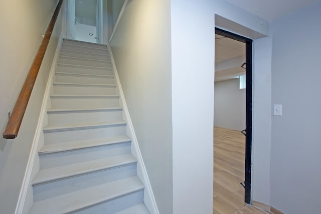 stairs featuring hardwood / wood-style floors