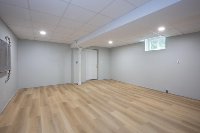 basement featuring light hardwood / wood-style floors and a paneled ceiling